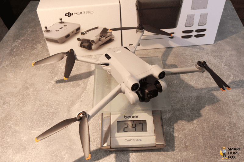 Die DJI Mini 3 Pro liegt mit eingelegten Akku auf einer Waage und wiegt 247 Gramm.